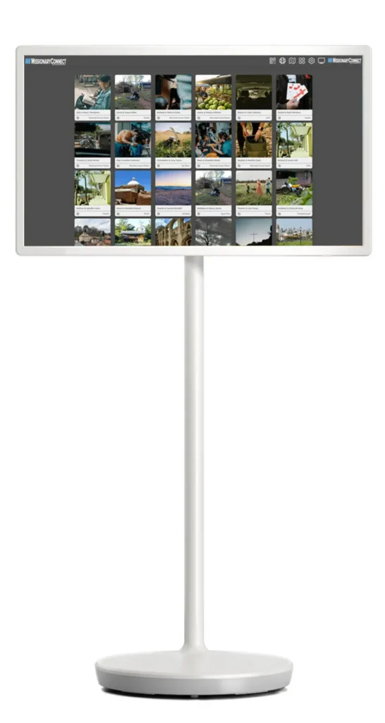 32-inch Digital Missions Display pedestal kiosk showing the MissionaryConnect Grid View of missionary family cards